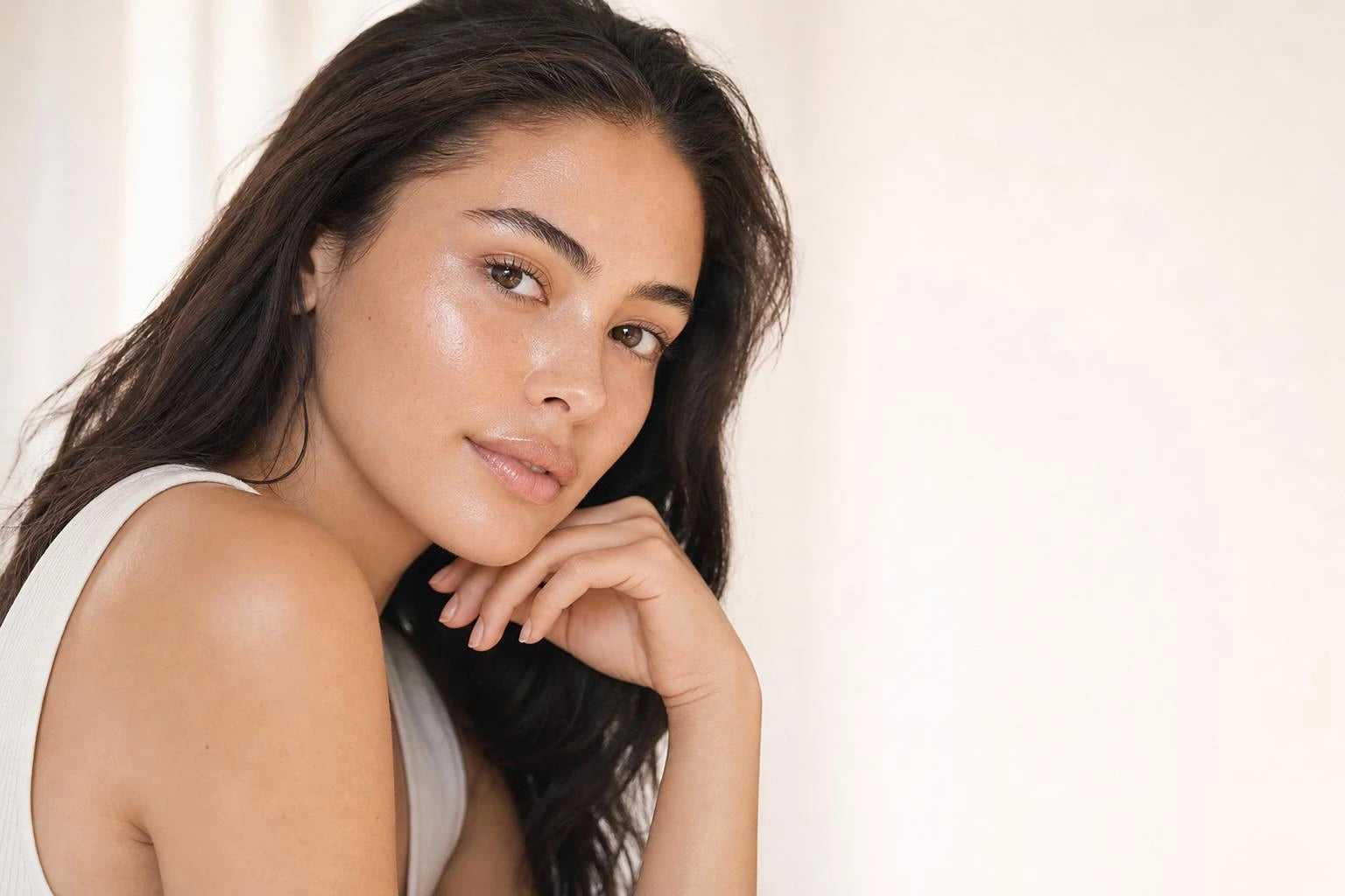 Woman gliding the Volée Pink Balm along her cheekbone, glass-skin glow