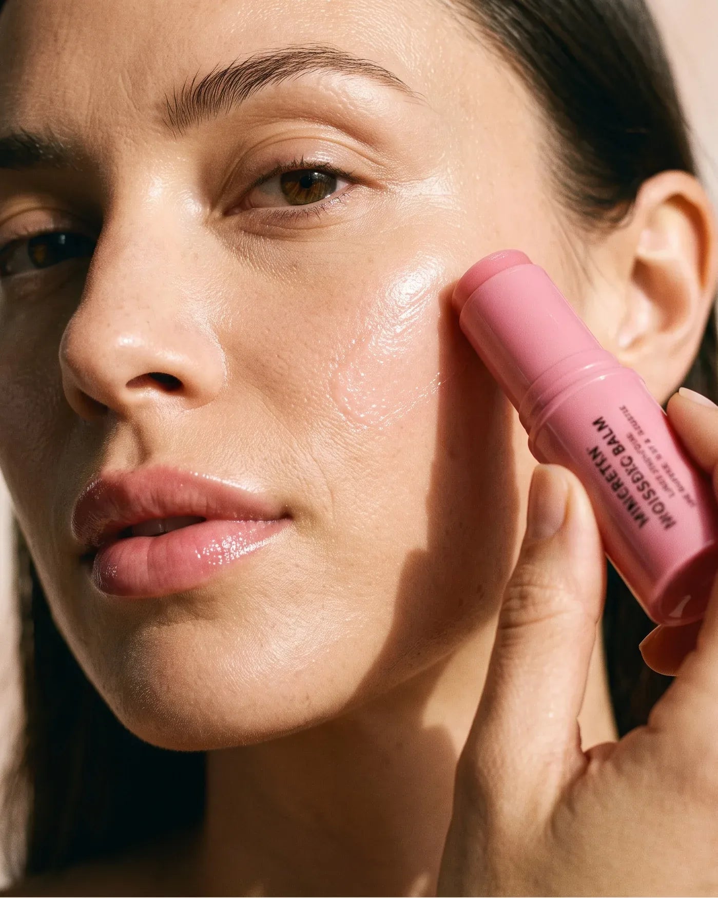 Woman applying the Pink Balm at home, natural light